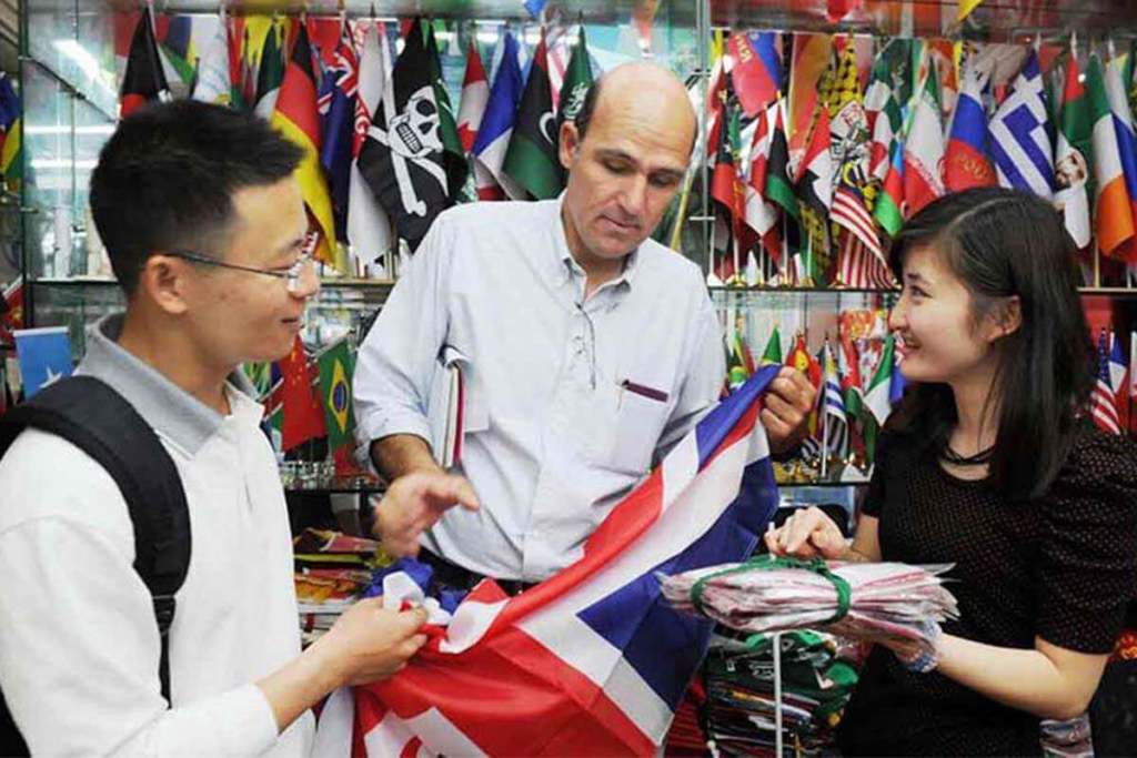 A foreign buyer is negotiating at a flag booth with an agent